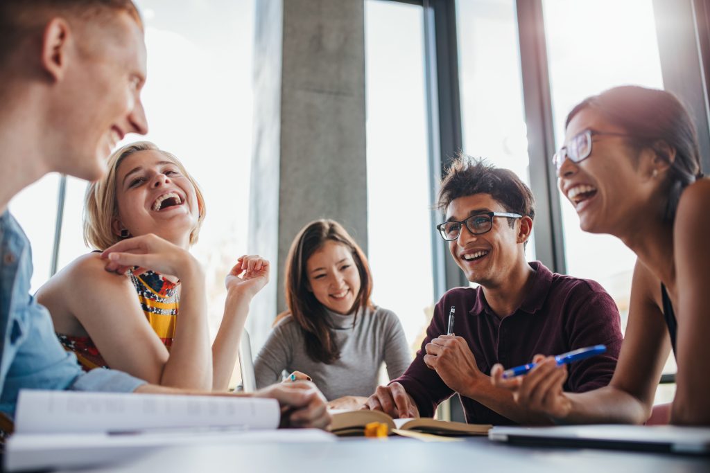 Studenti felici che ridono assieme mentre studiano